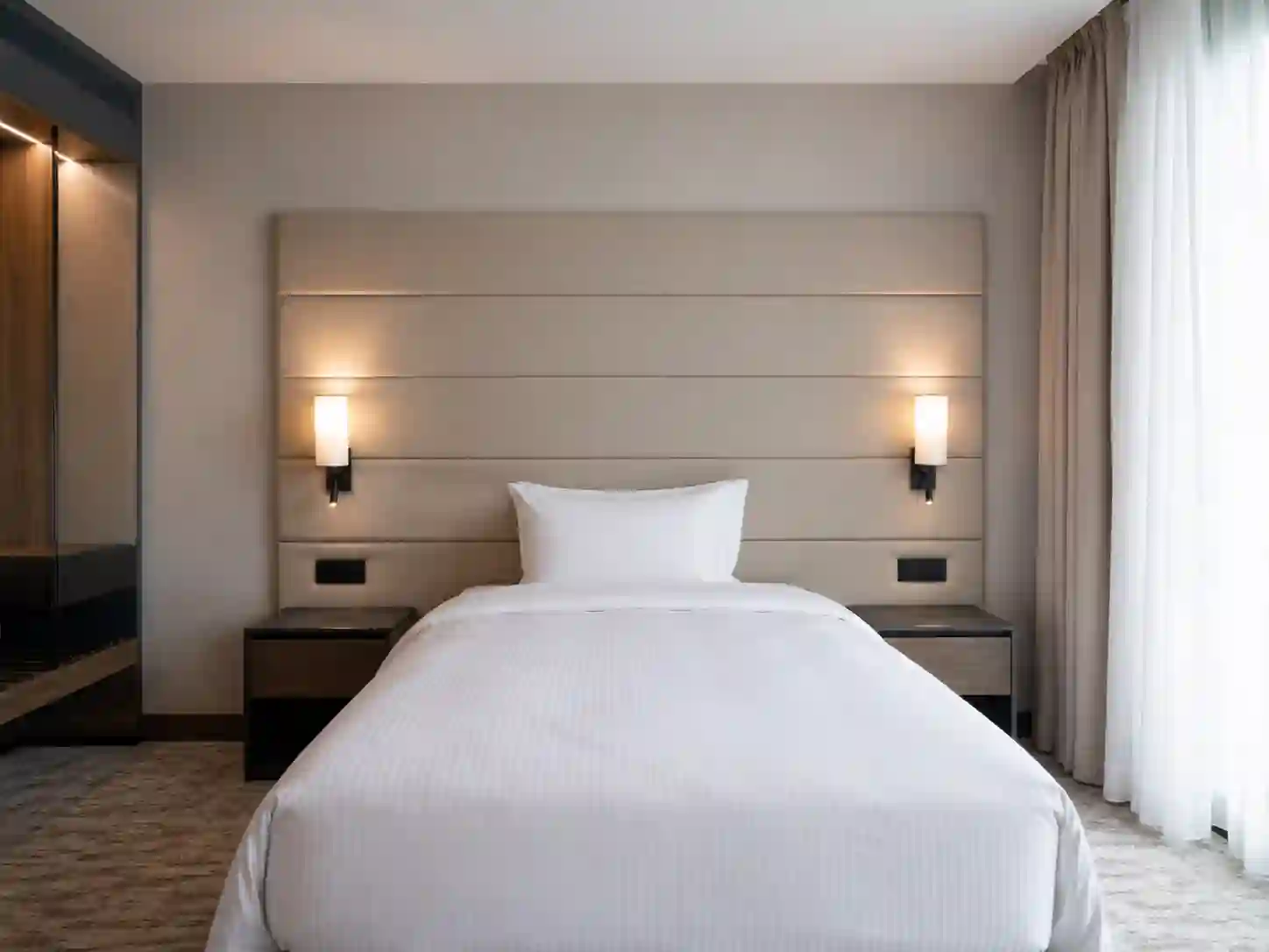 Panel ścienny nad łóżkiem hotelowym z kinkietami i gniazdami