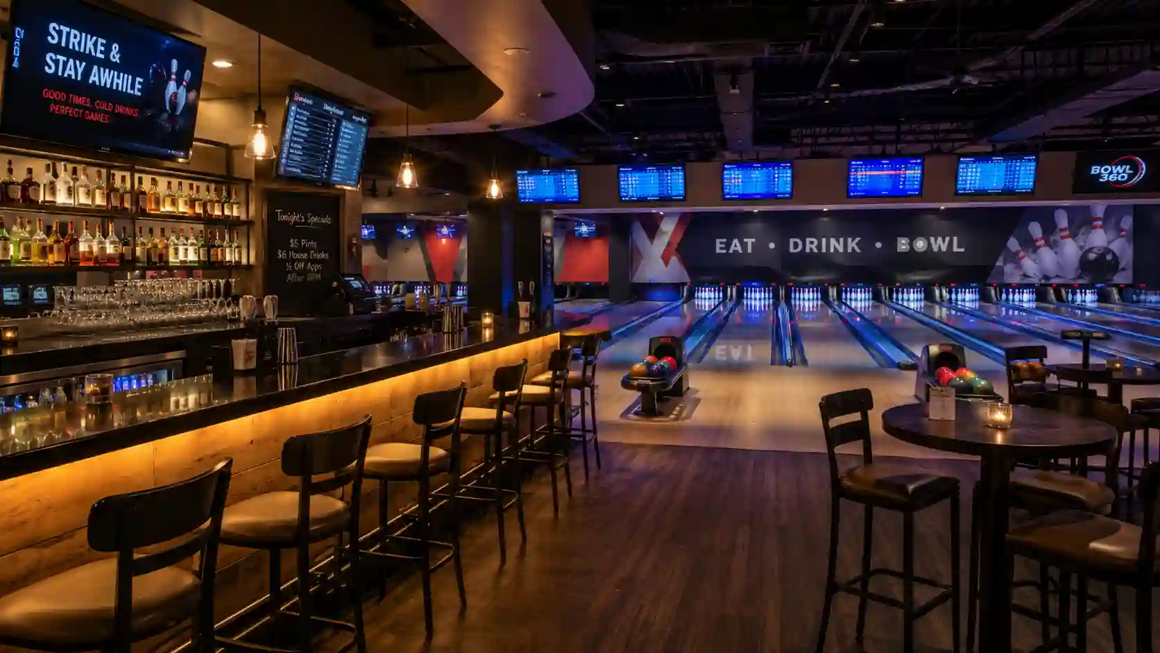 Bar przy torach bowlingowych z miejscami siedzącymi i widokiem na strefę gry