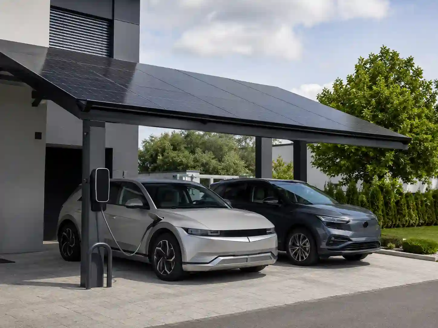 Wiata fotowoltaiczna z ładowarką 11–22 kW zamontowaną na stalowym słupie.