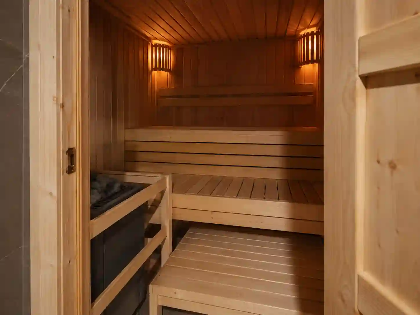 Klasyczna sauna fińska z osłoniętymi lampami punktowymi przy ścianach.