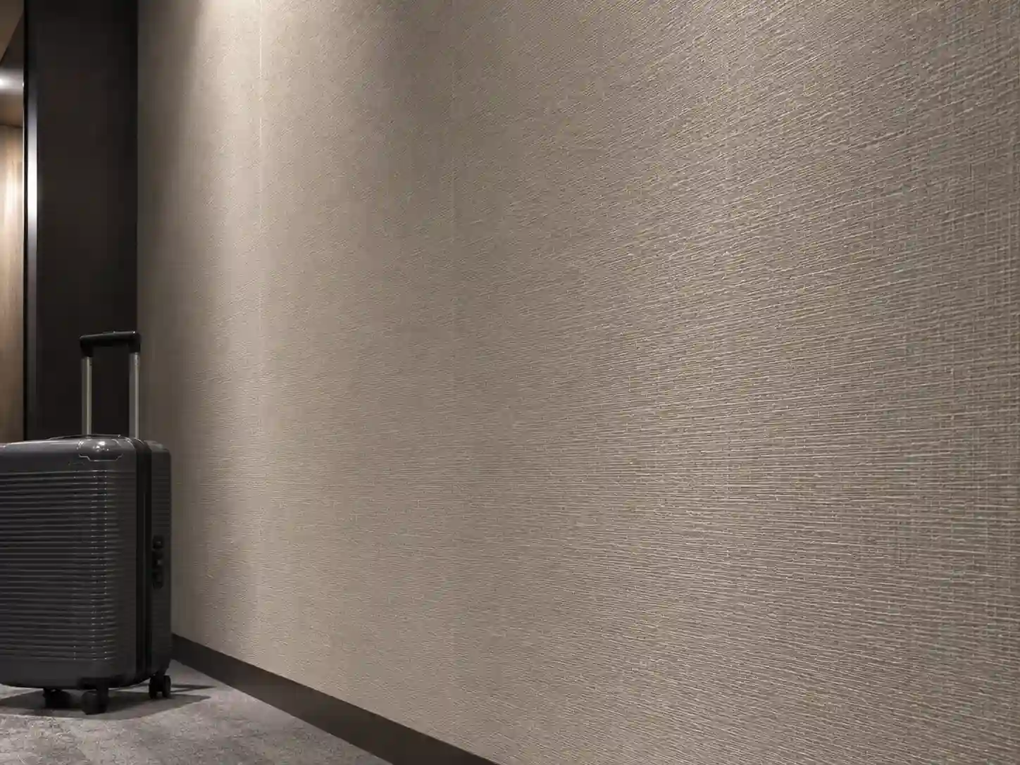 Winylowa tapeta hotelowa o subtelnej strukturze na ścianie za łóżkiem.