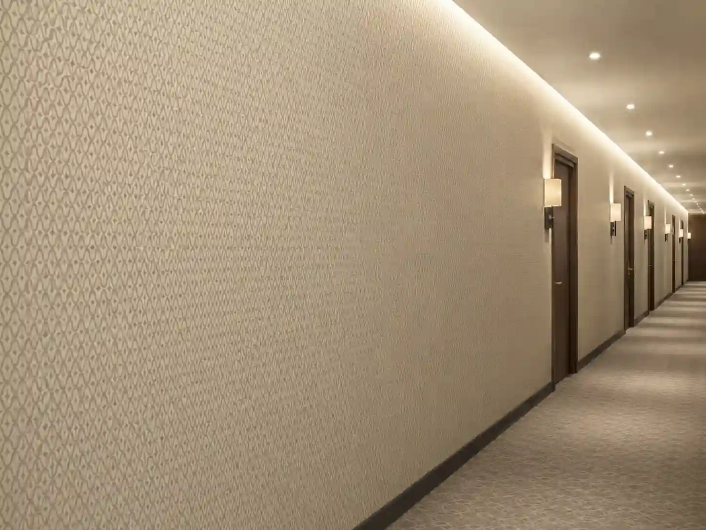 Tapeta hotelowa z drobnym geometrycznym wzorem o raporcie około 8 cm.
