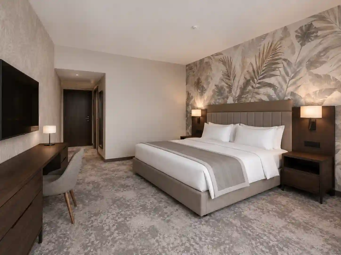 Tapeta hotelowa na ścianie za łóżkiem i ścianie telewizyjnej.