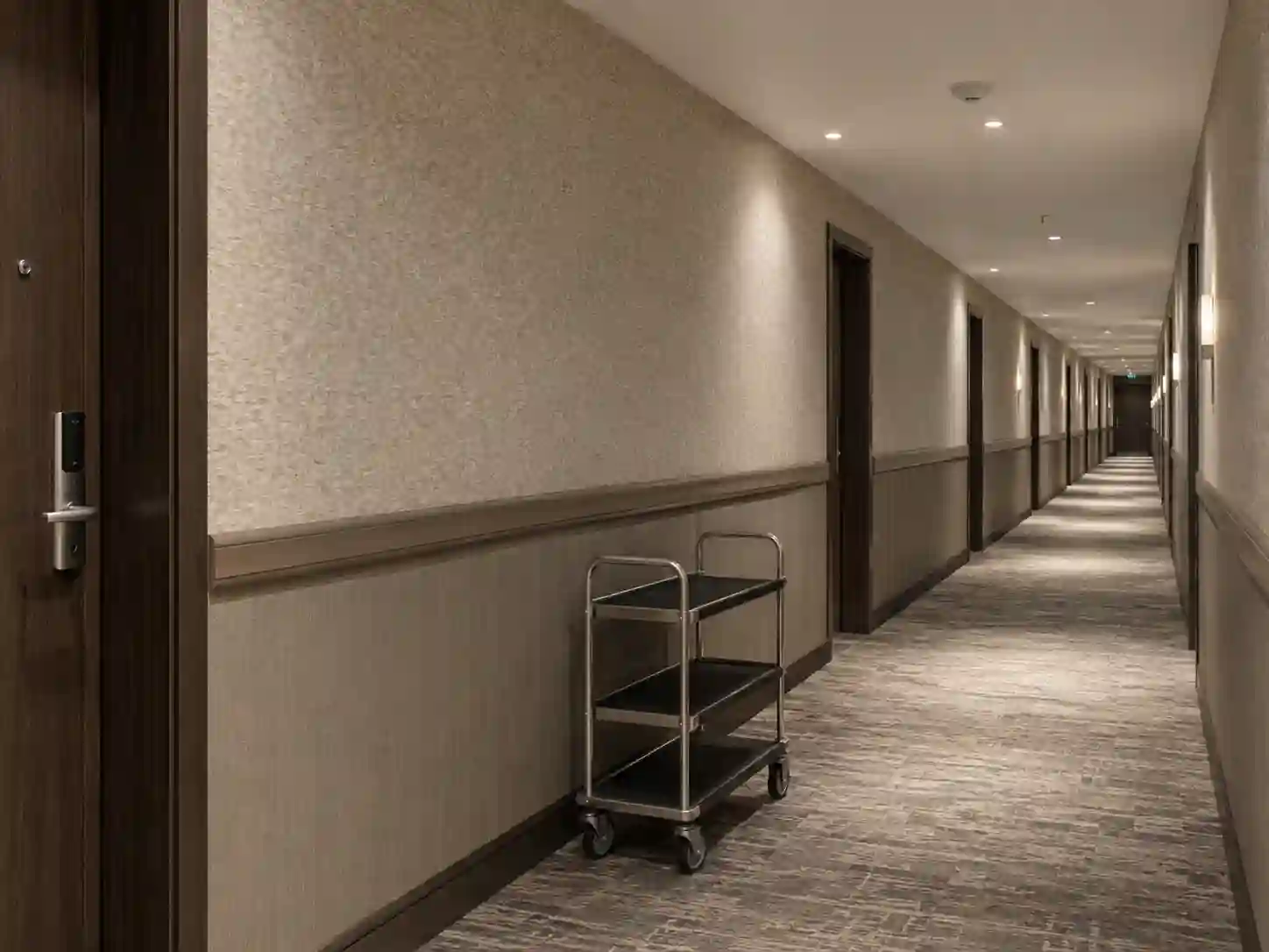 Wzmocniona tapeta hotelowa z dolnym panelem ochronnym w korytarzu.