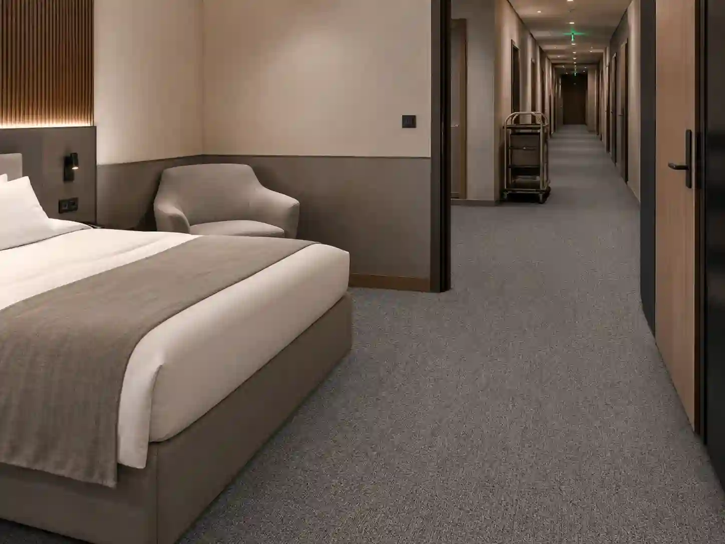 Ten sam wzór wykładziny zastosowany w pokoju i hotelowym korytarzu.